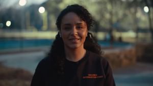 Women smiling at the camera as she speaks wearing a violence intervention staff shirt