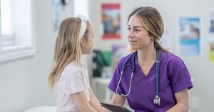 Female doctor smiling at a young blonde patient