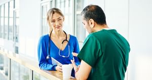 A male and female health care professional chatting