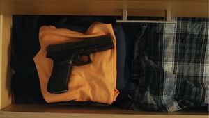 A handgun in a drawer of clothes shot viewed from above