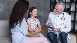 Doctor listening to a young girl during a medical consultation with her mother
