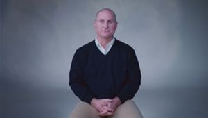 Brendon Campbell sitting facing the camera with his hands crossed in his lap