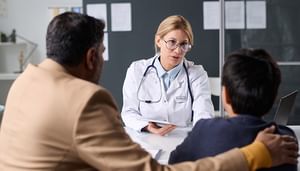 Female doctor consulting father and son
