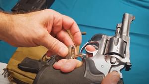 A hand holding a hand gun with a lock and key