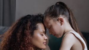 Parent and child with their foreheads together and eyes closed