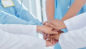 Close up of doctors and health care professionals putting their hands in a stack
