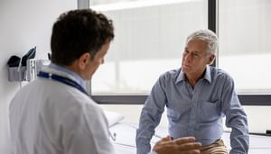 Doctor talking to a male adult patient in a consultation at the office